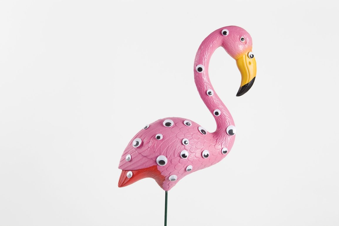 Pink flamingo figurine on white background