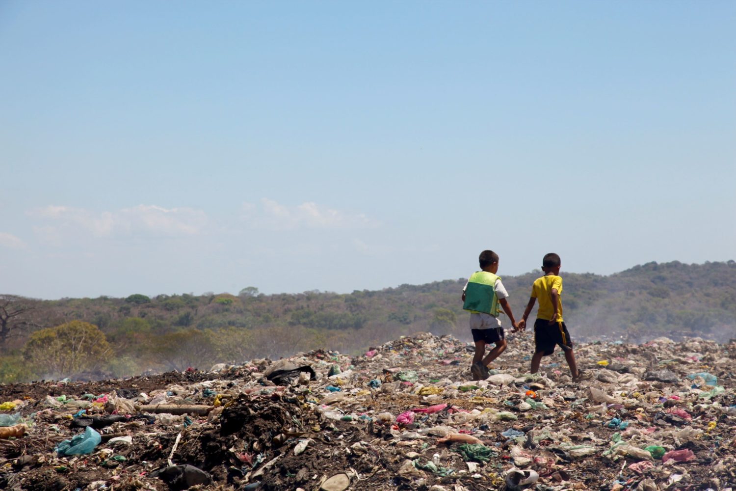 2 boys collecting items in a landfill
