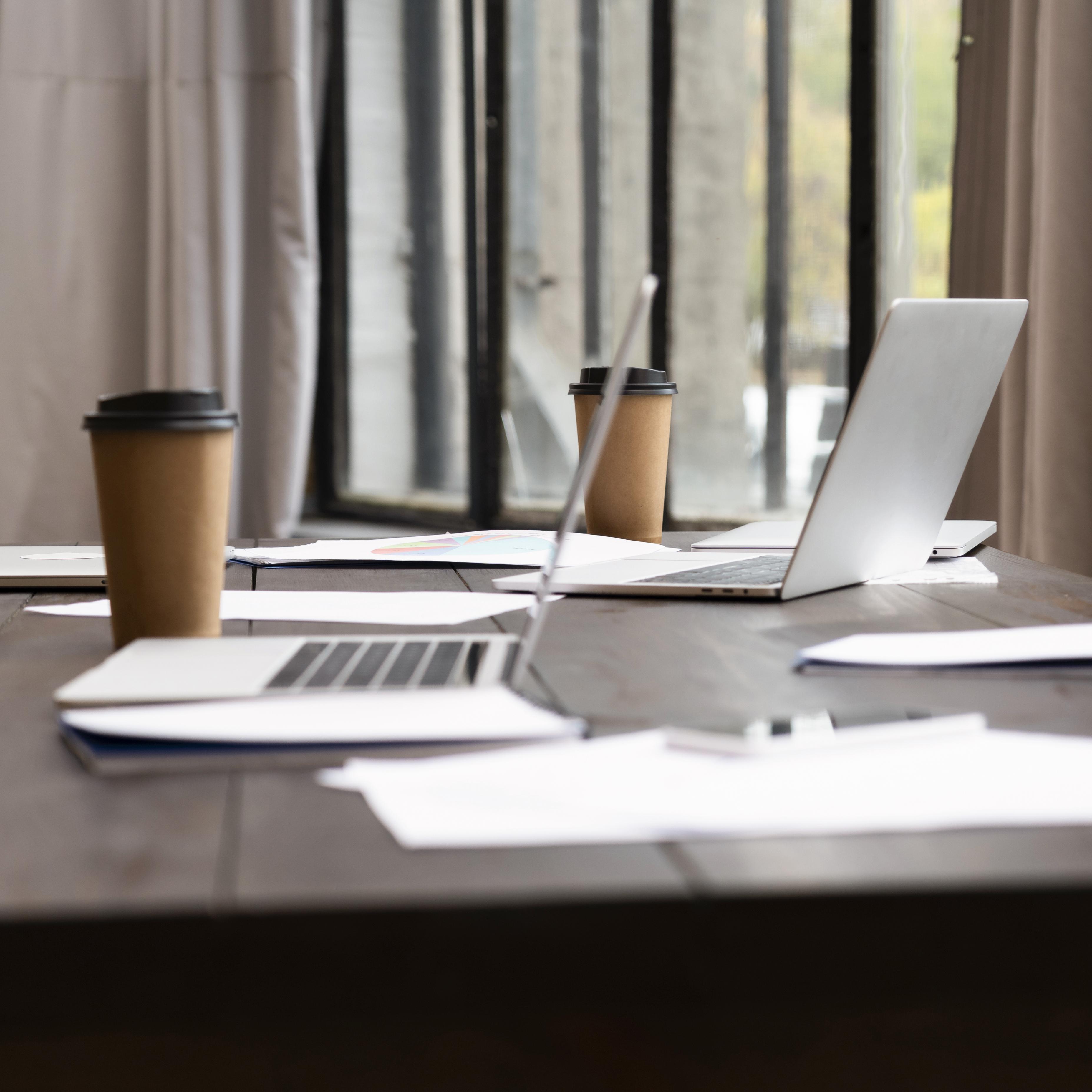 office desk with laptop and cardboard coffee cup