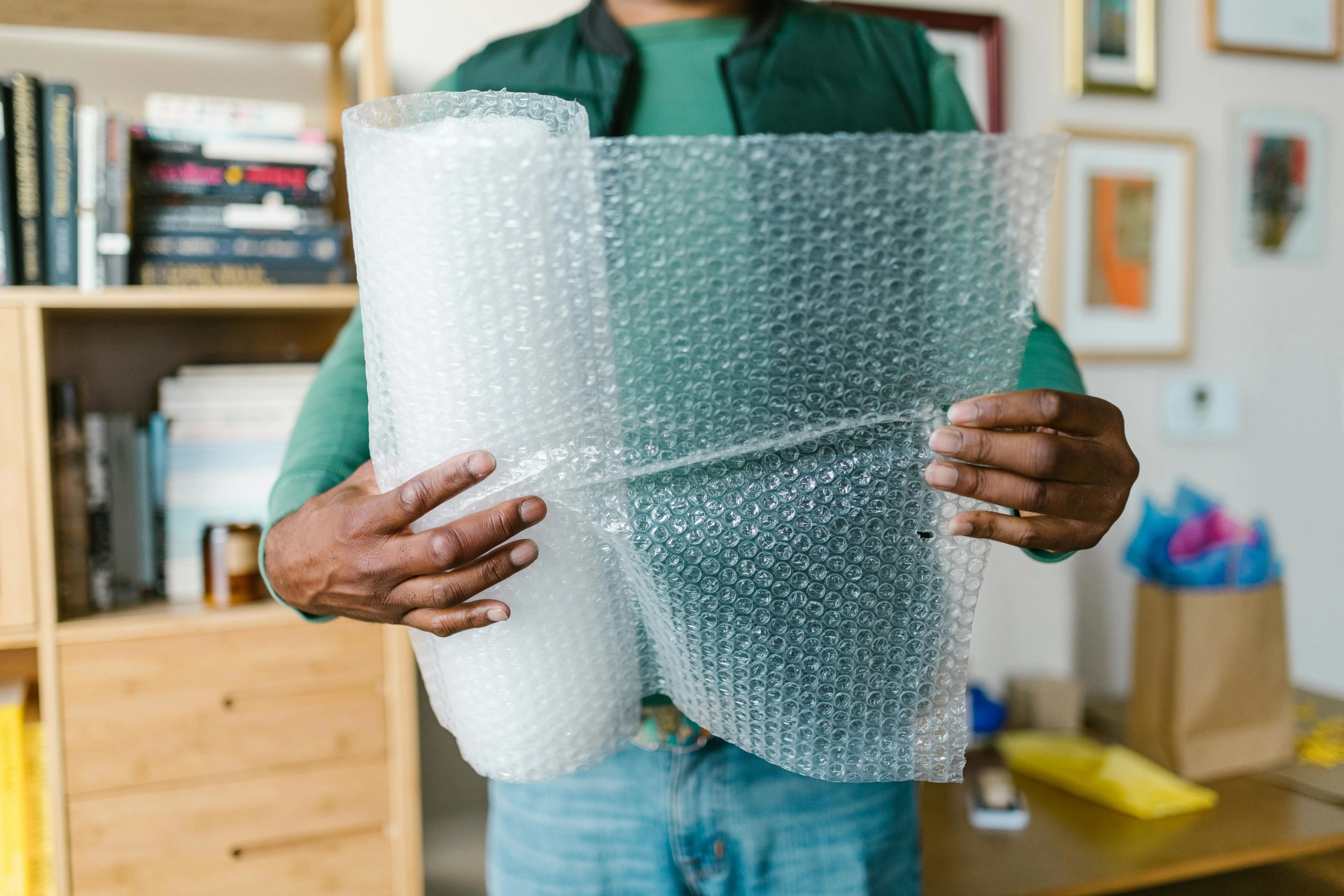 person unravelling roll of bubble wrap