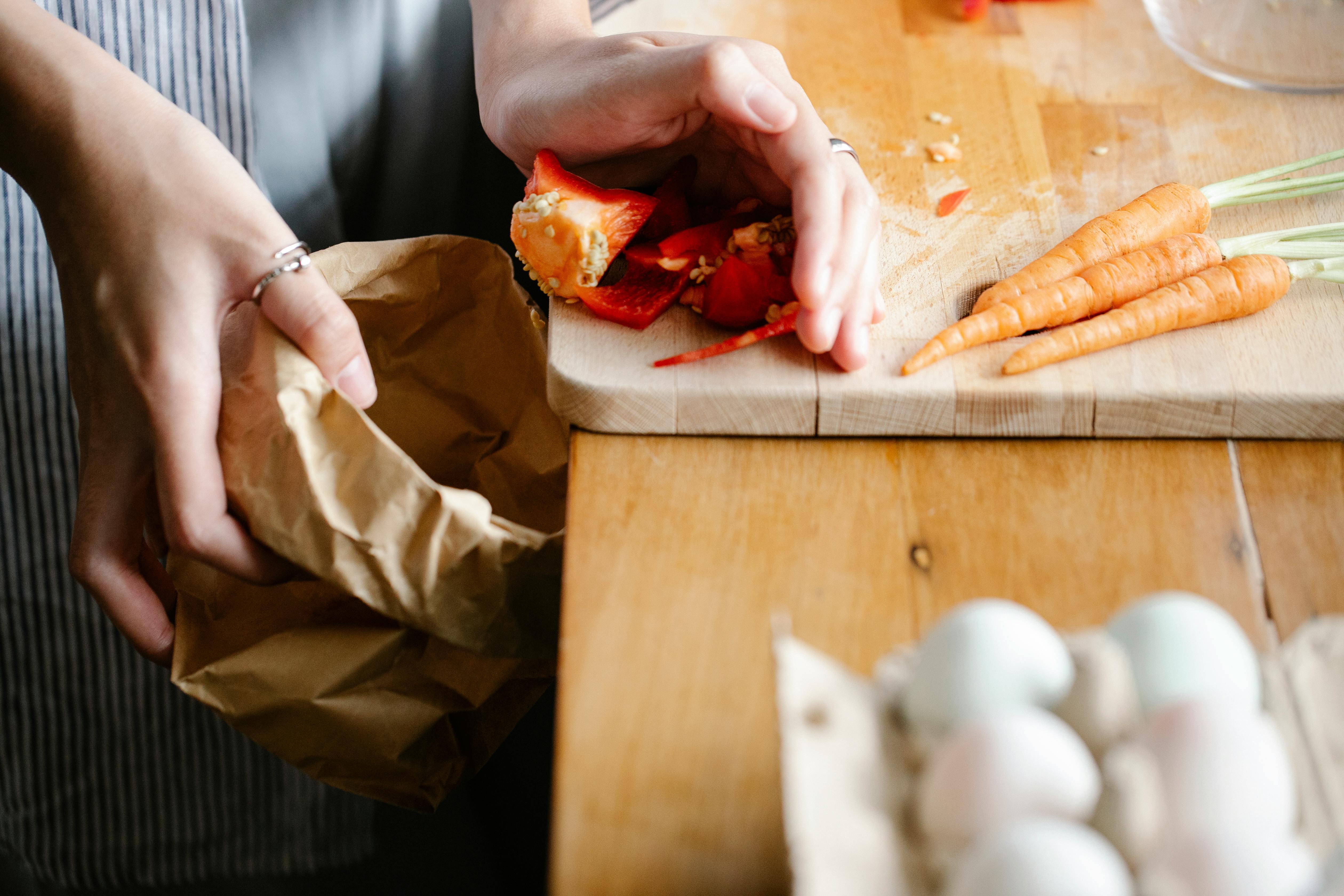 Crop woman cleaning cutting board in kitchen