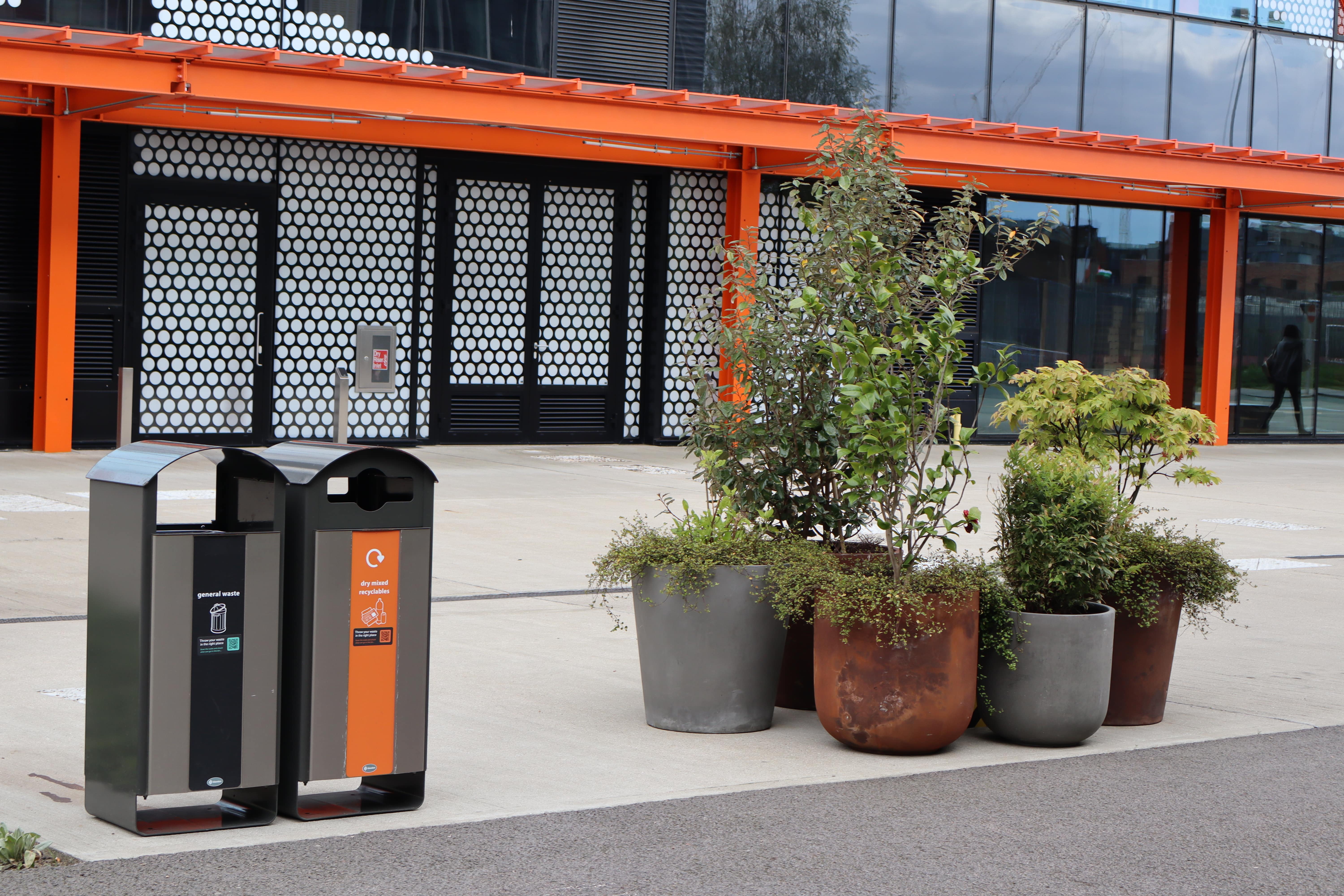 Exterior view of a building with General Waste and Dry Mixed Recycling bins in the foreground