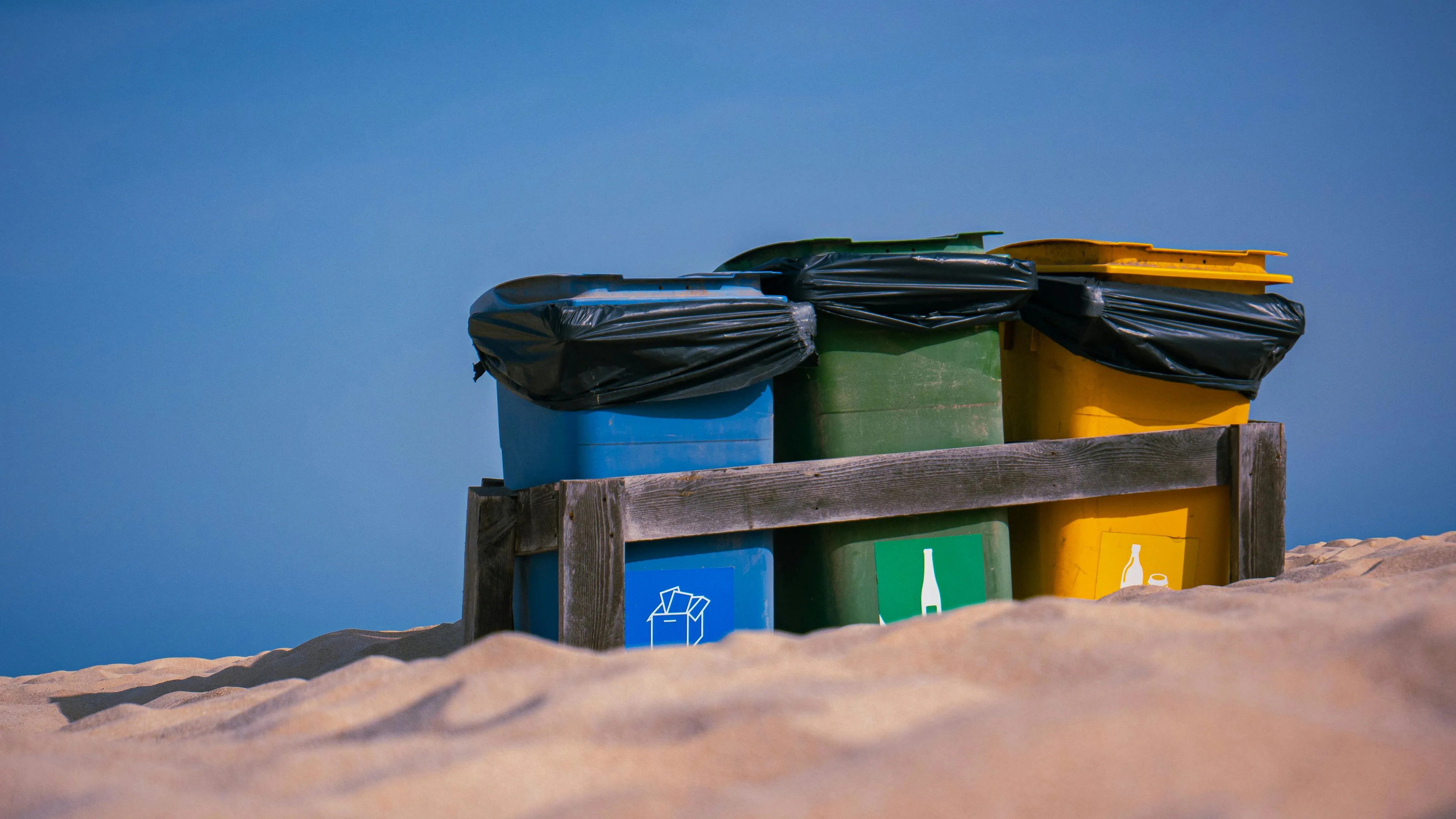 Recycling bins on sand
