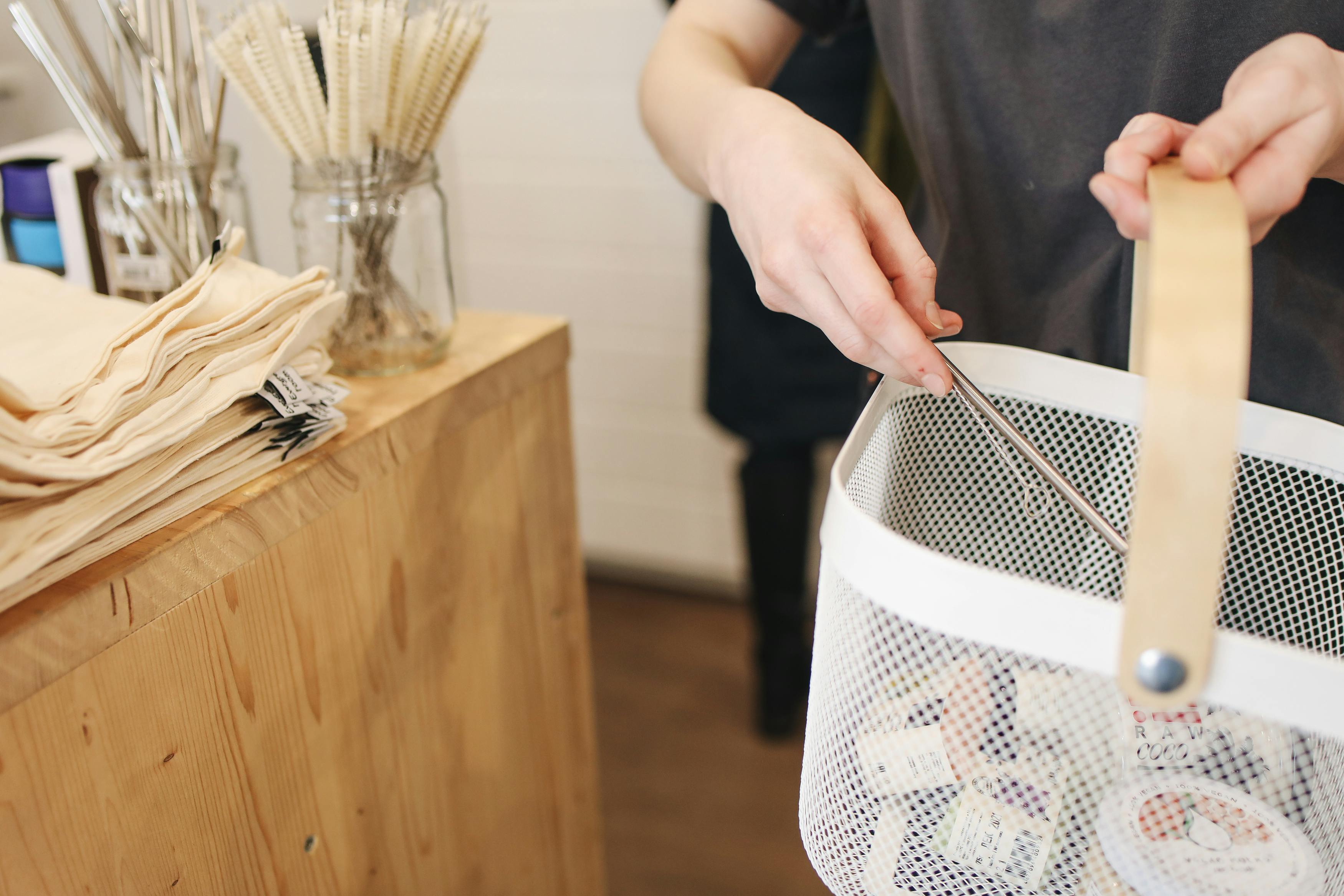 Person holding white plastic basket
