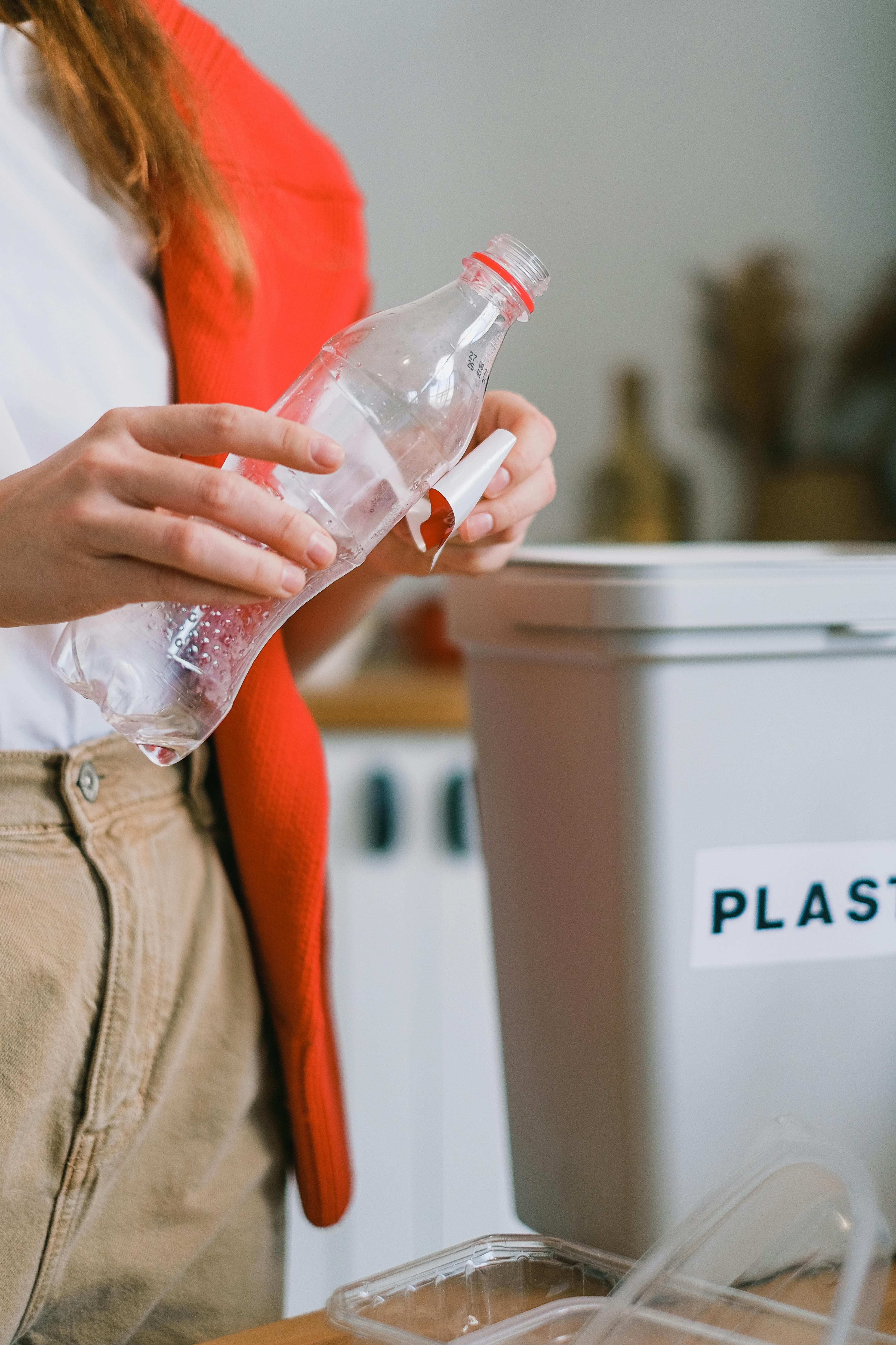 Person removing a label from a plastic bottle