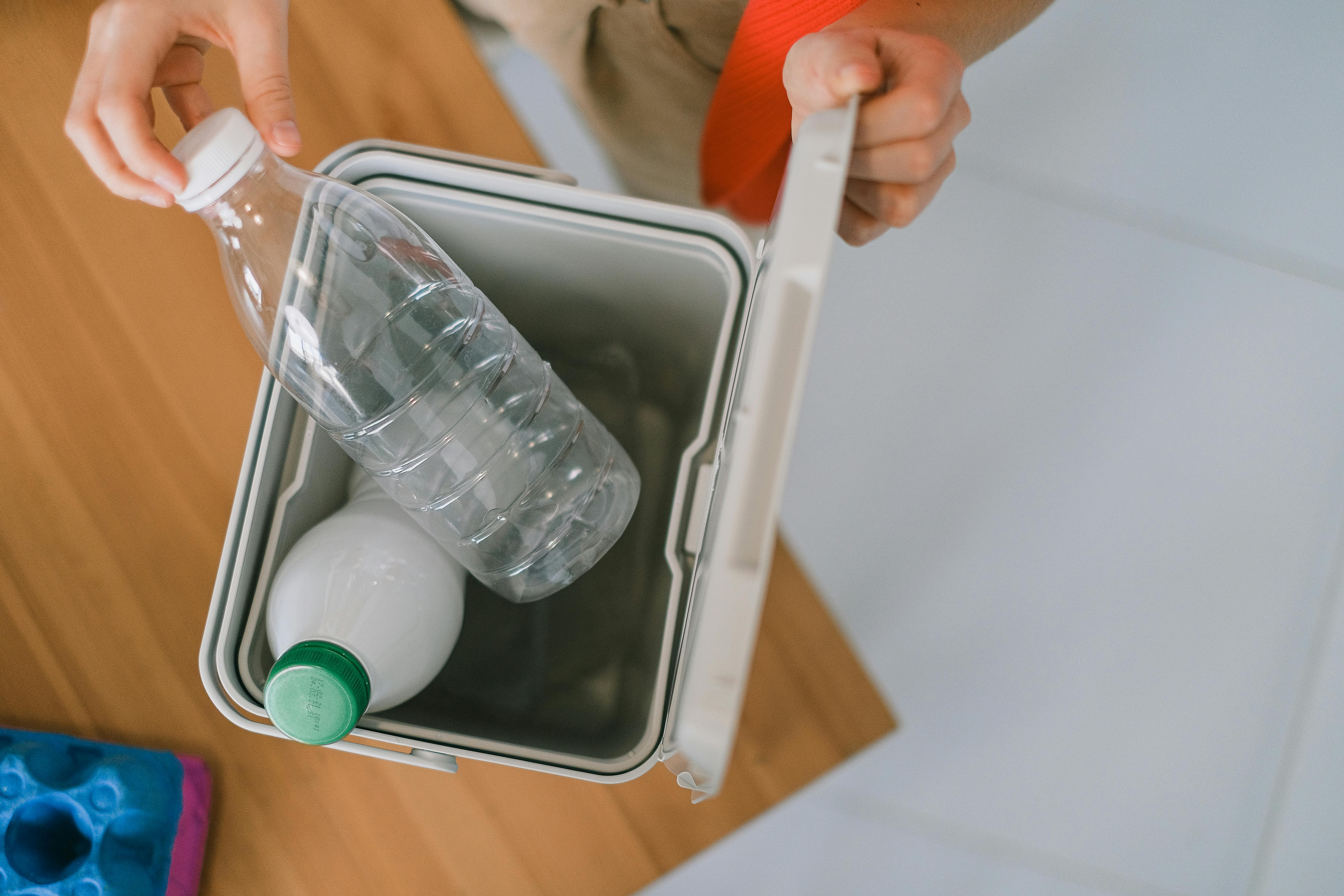 Person disposing plastic bottles into a container