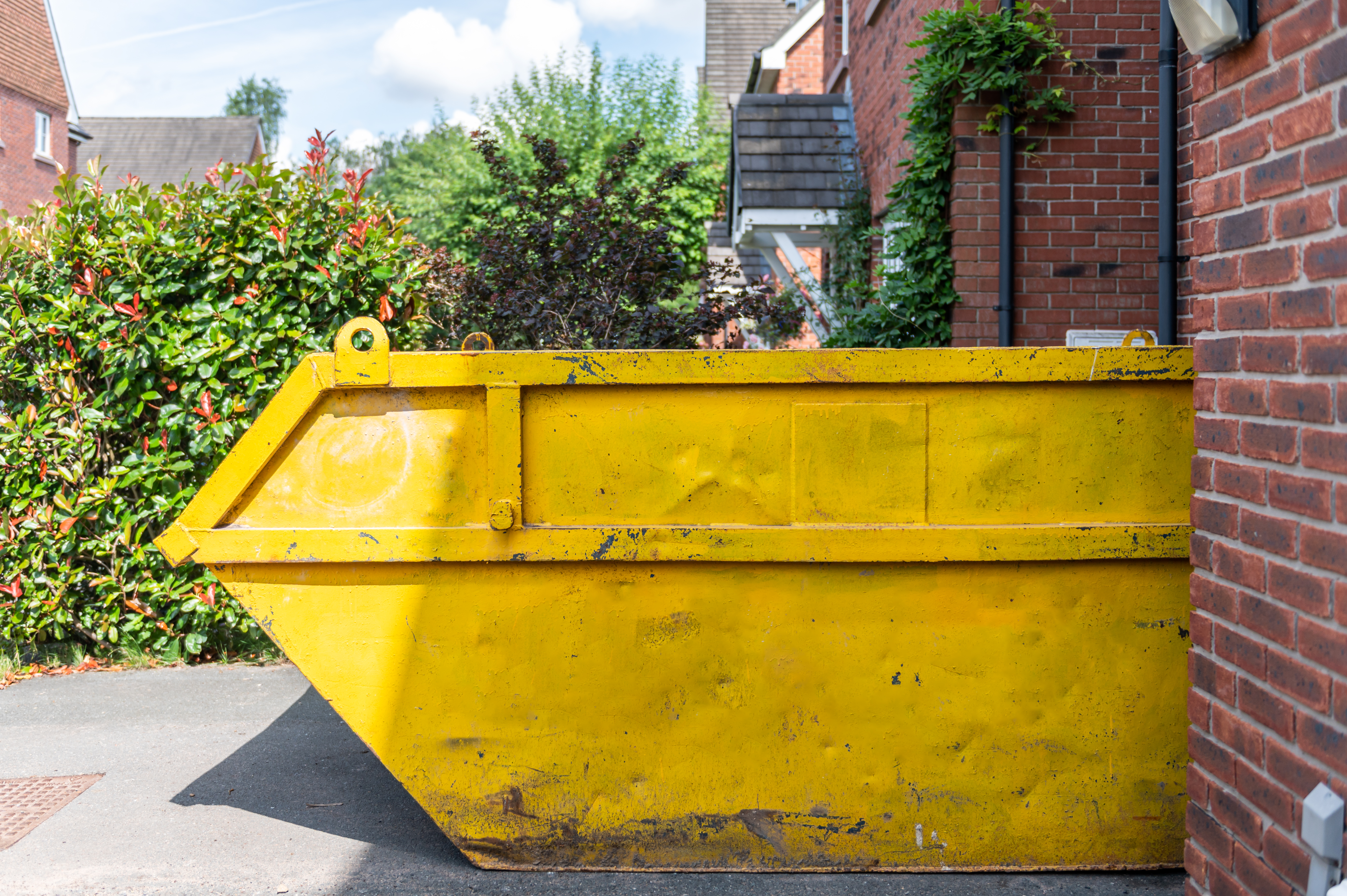 Yellow skip on driveway