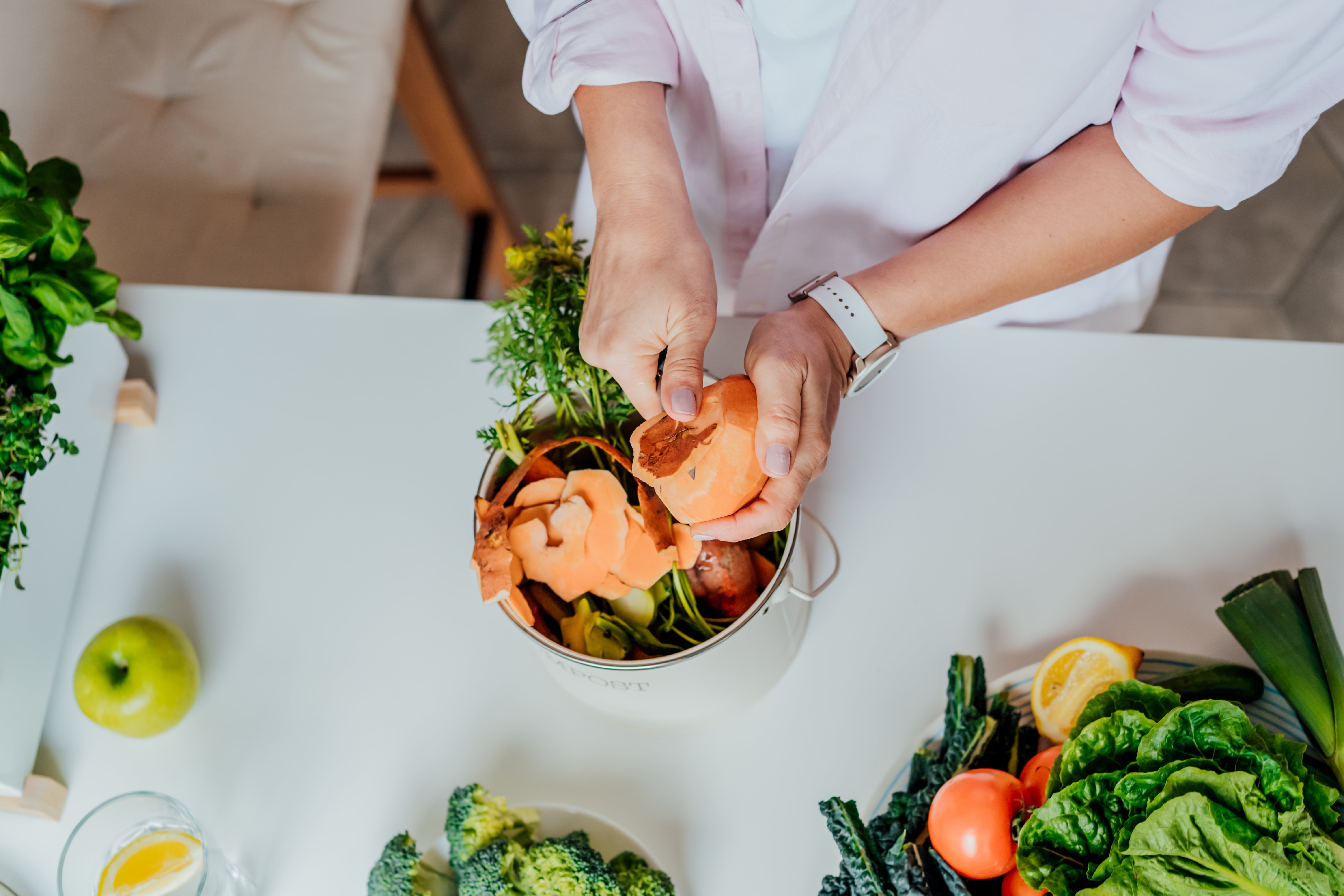 Woman composting kitchen waste at home