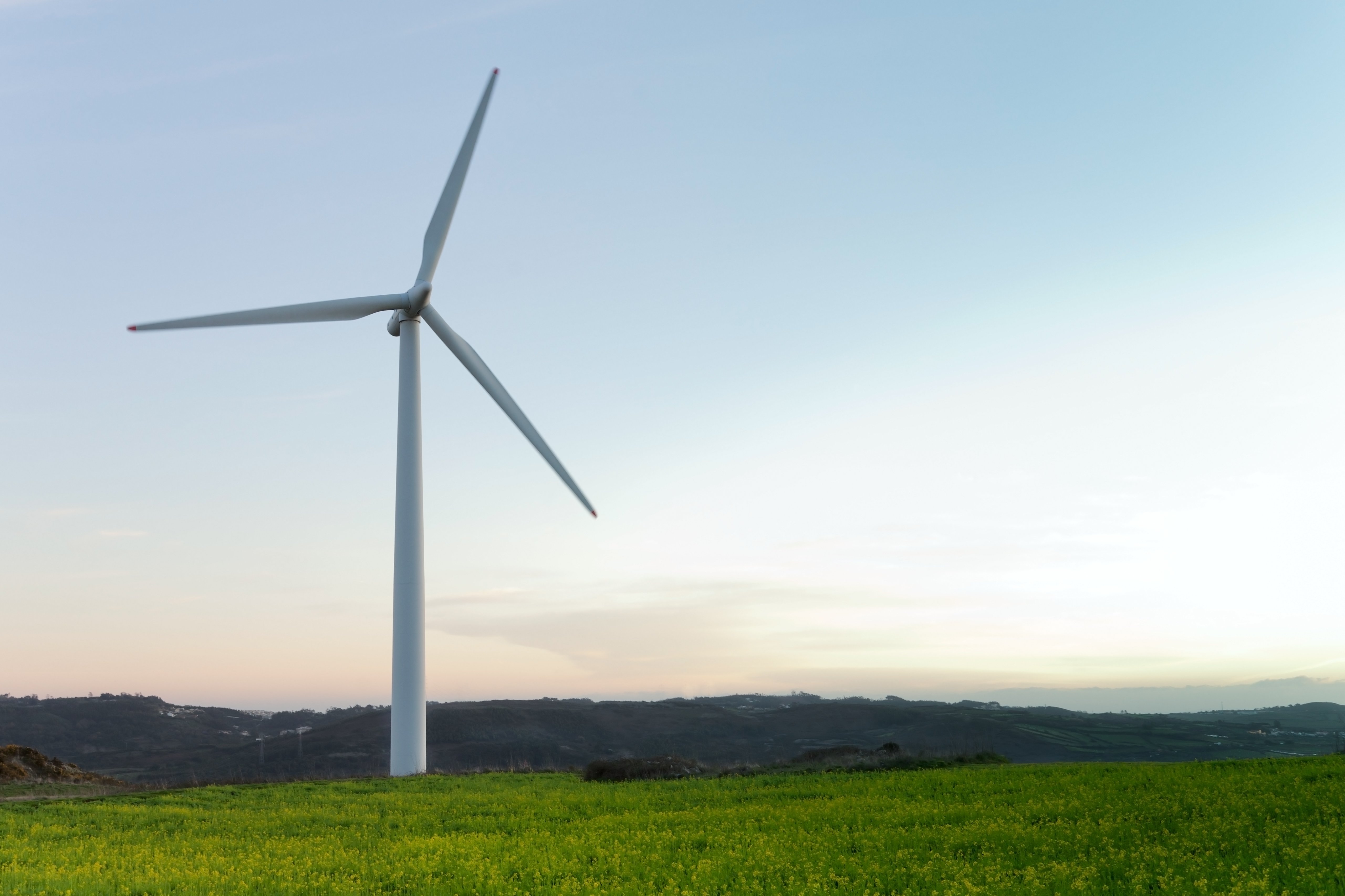 Wind turbine generating renewable energy against a clear sky