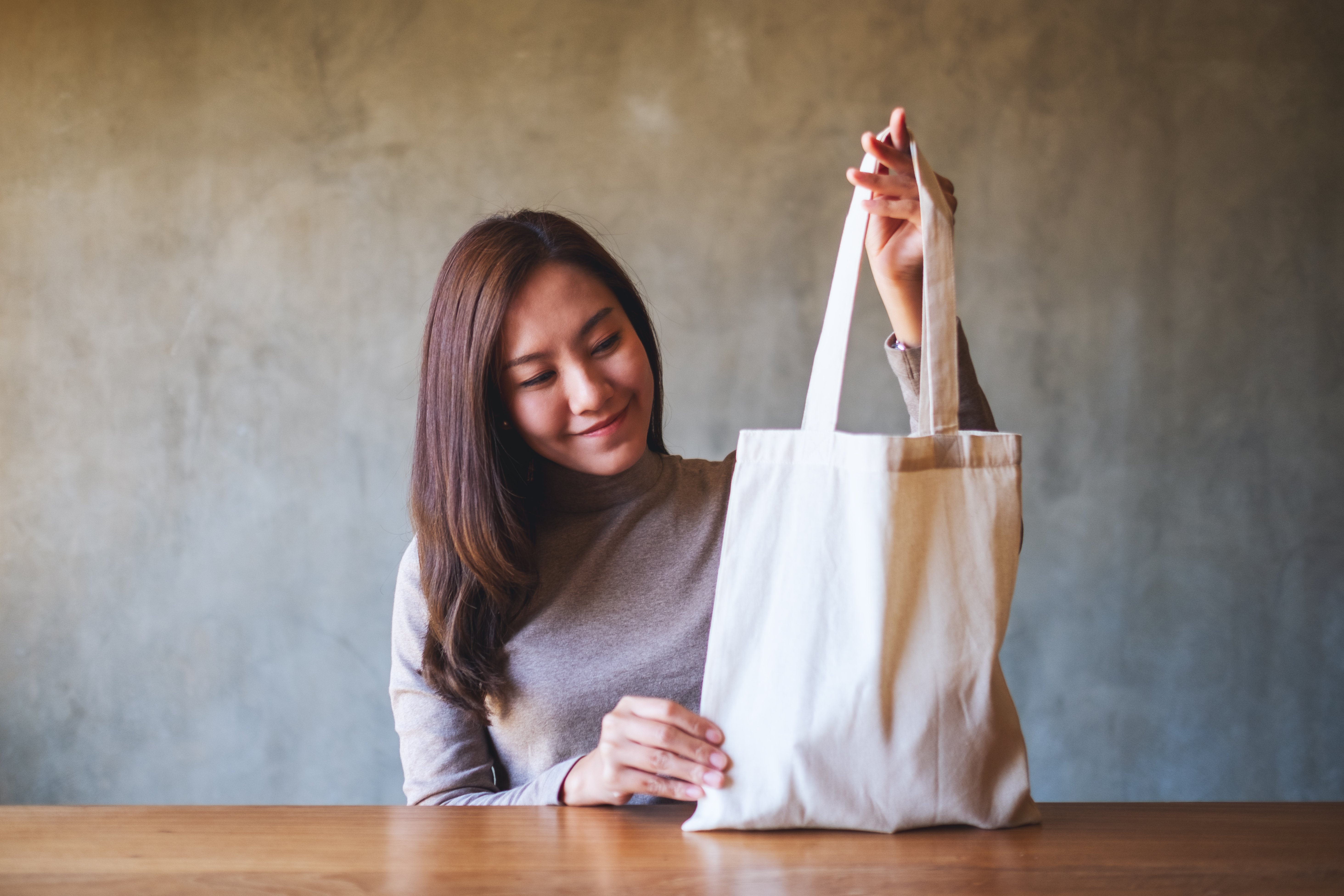 Woman holding a white fabric tote bag