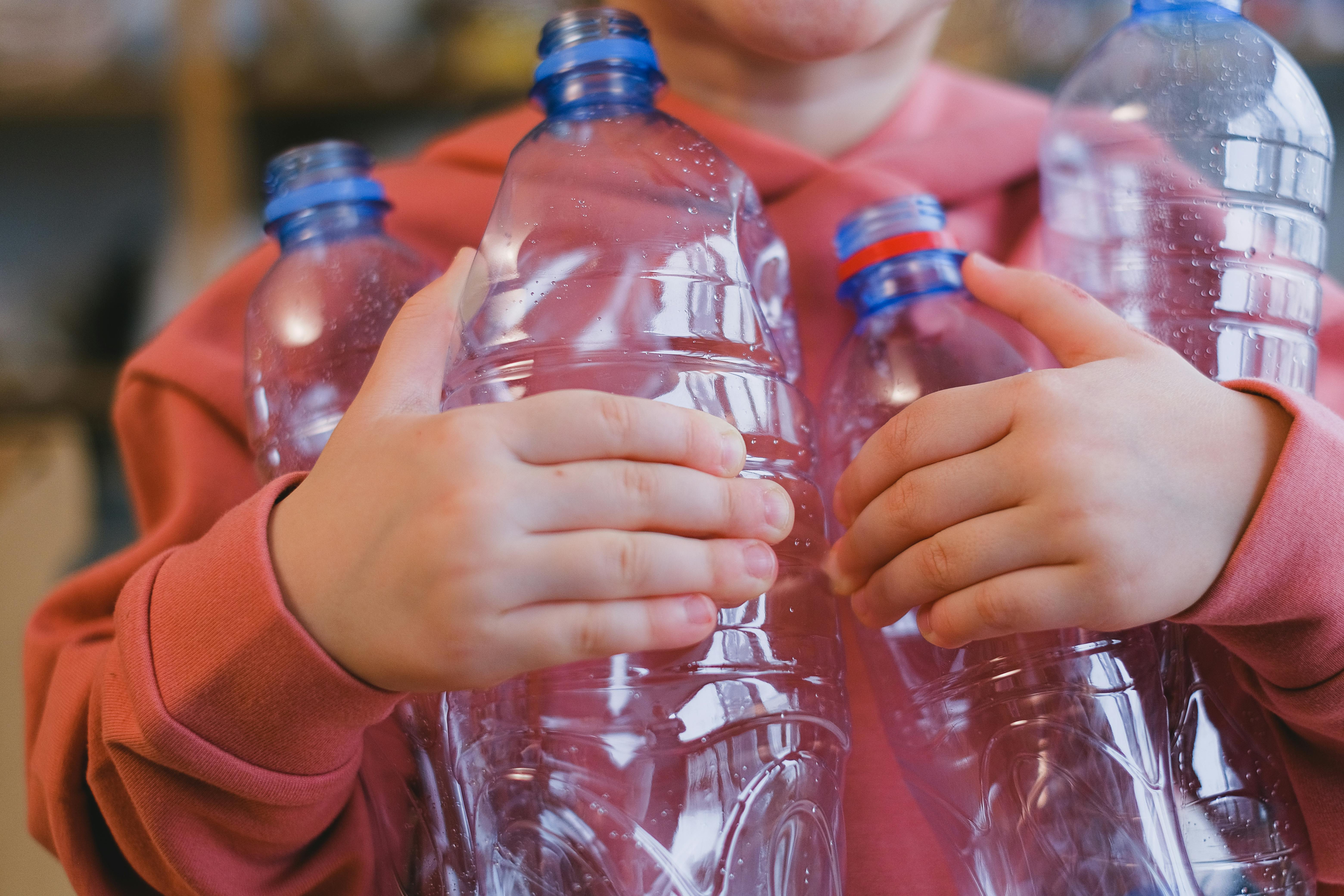 child holding empty plastic bottles