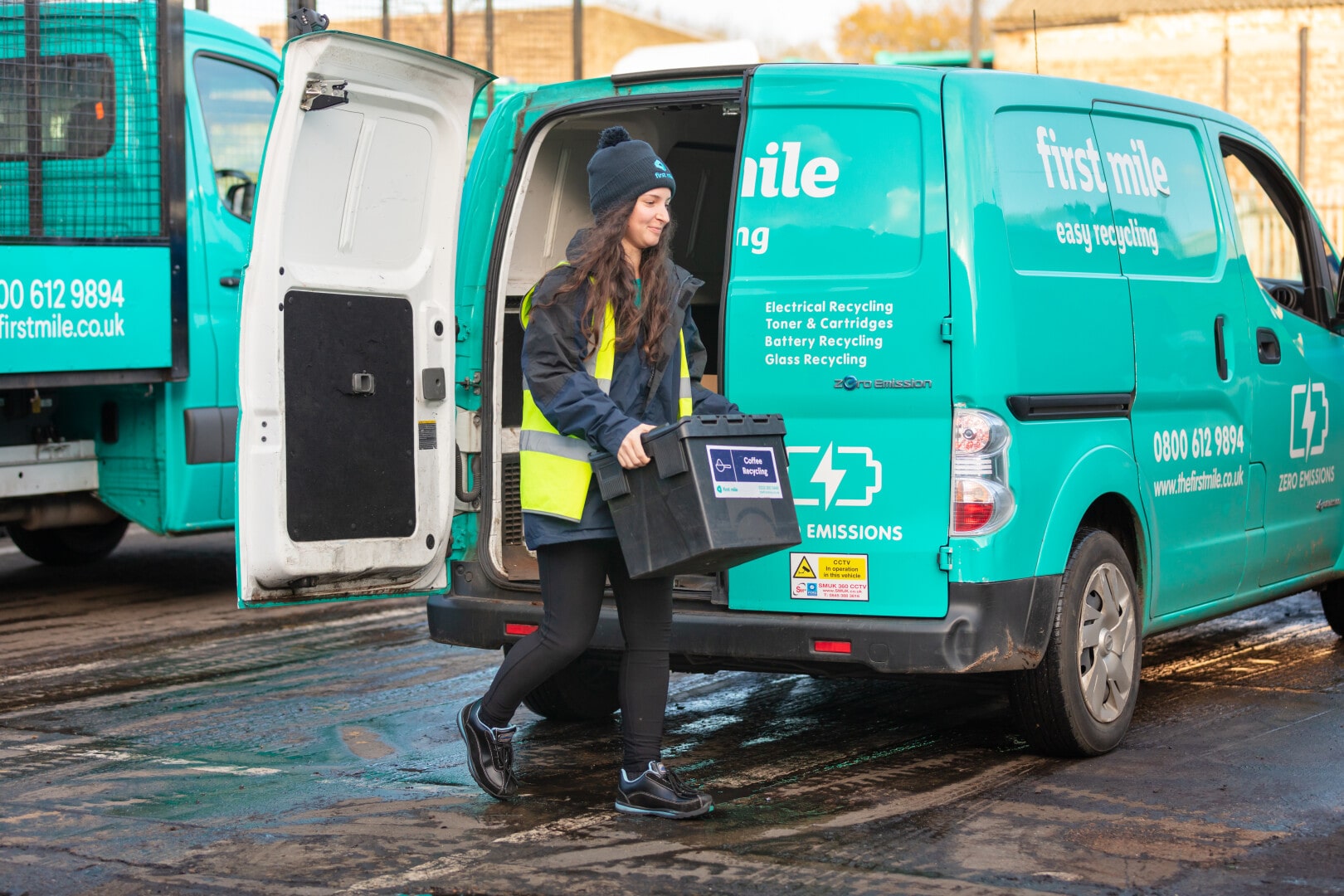 First Mile worker in front of van holding a crate