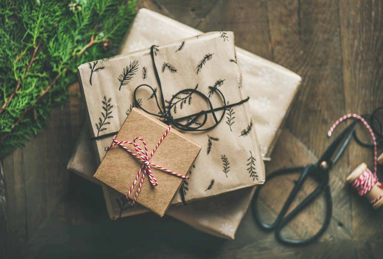Multiple boxes wrapped for Christmas with scissors and string next to them
