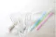 Plastic cutlery in front of plastic straws
