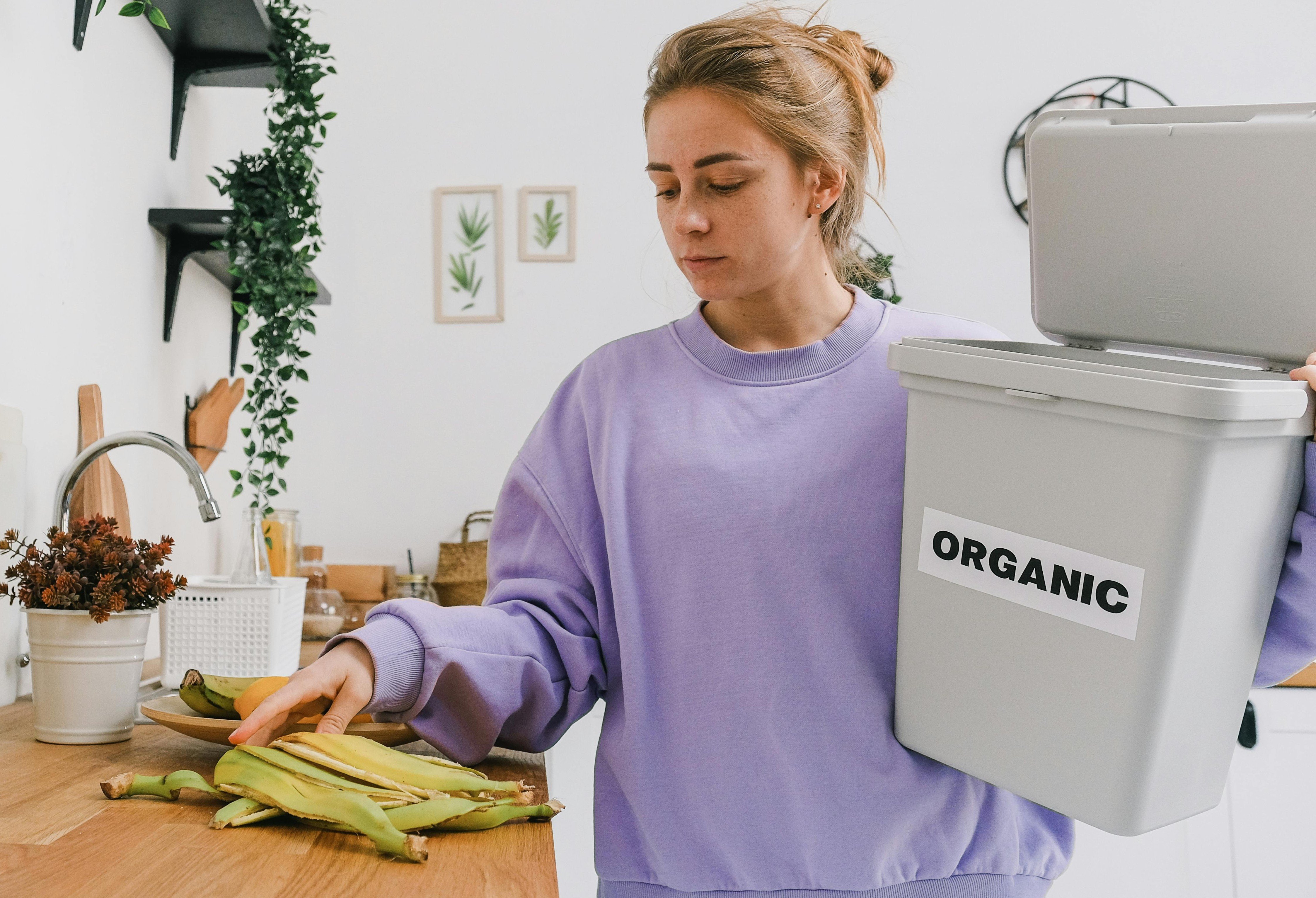 woman placing banana skin in clearly labelled food waste bin